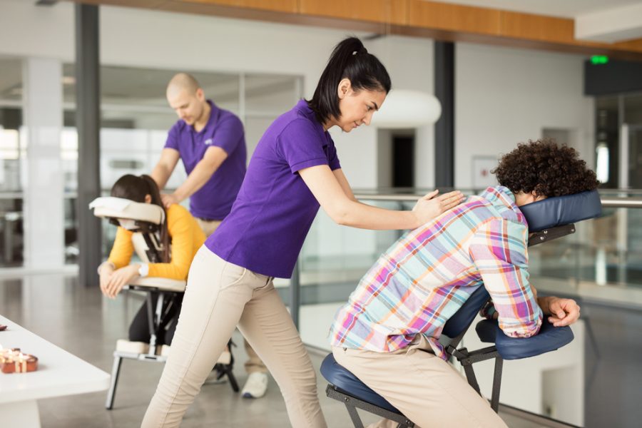 People receive back massage in office space