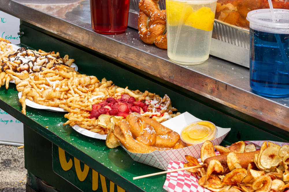 Plates of food and drink at a fairground vendor booth